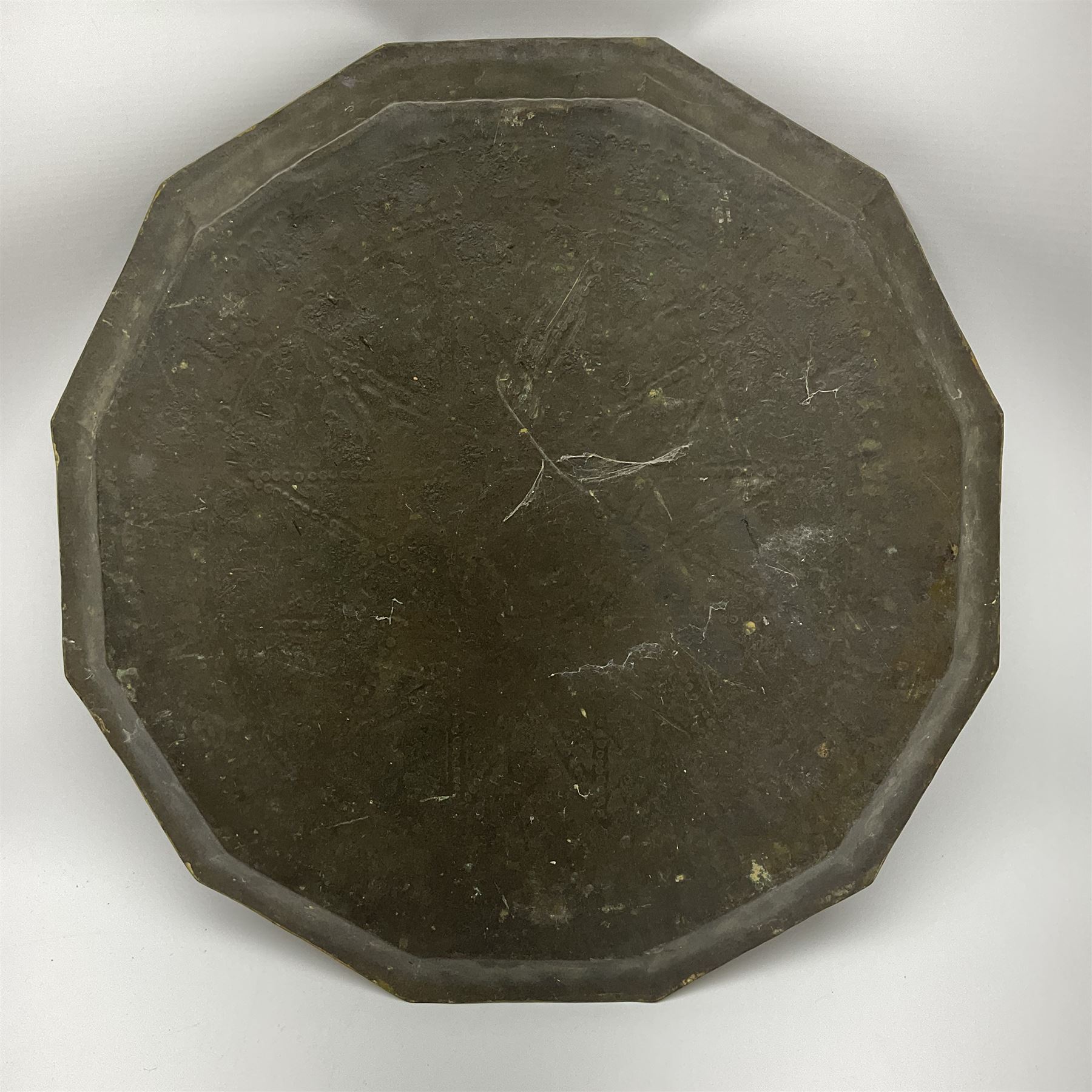 Eastern brass faceted tray with impressed script and scrolling decoration D48cm. 