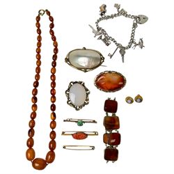 Three 9ct gold brooches, including two stone set examples, silver charm bracelet, amber ty...