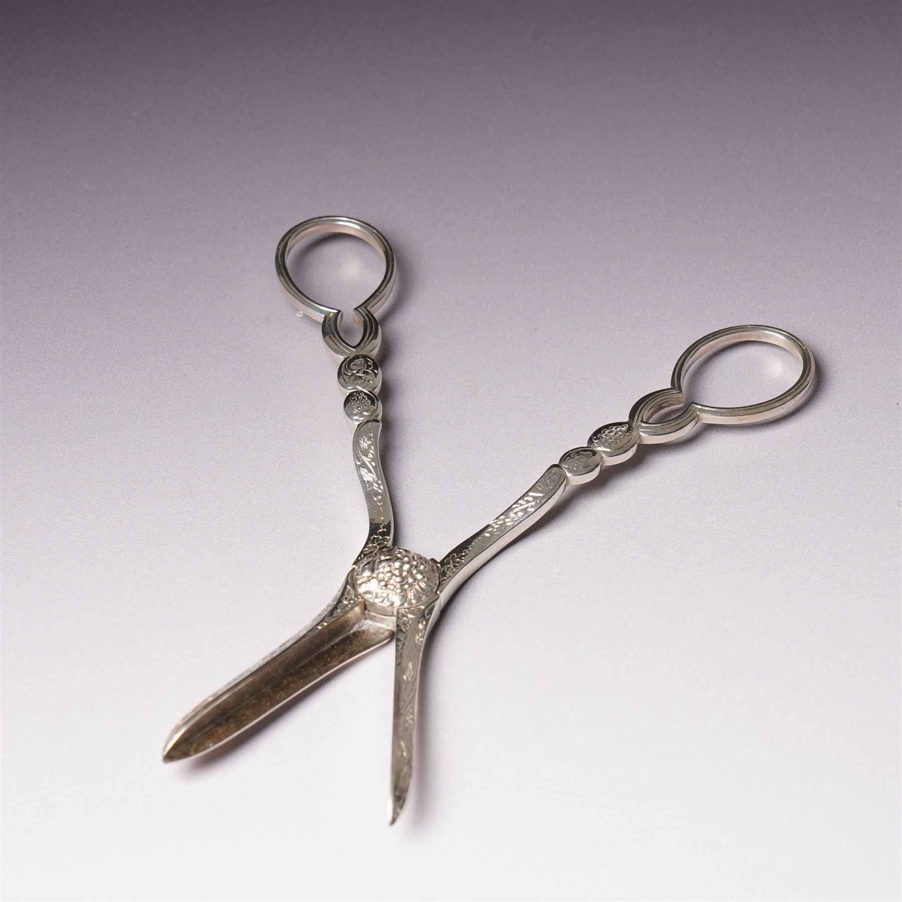 Pair of Victorian silver grape scissors with engraved decoration Birmingham 1860 Maker probably John Gilbert and a small silver sauce boat with crimped rim and C scroll handle Birmingham 1905 Maker Thomas Hayes (2)  
