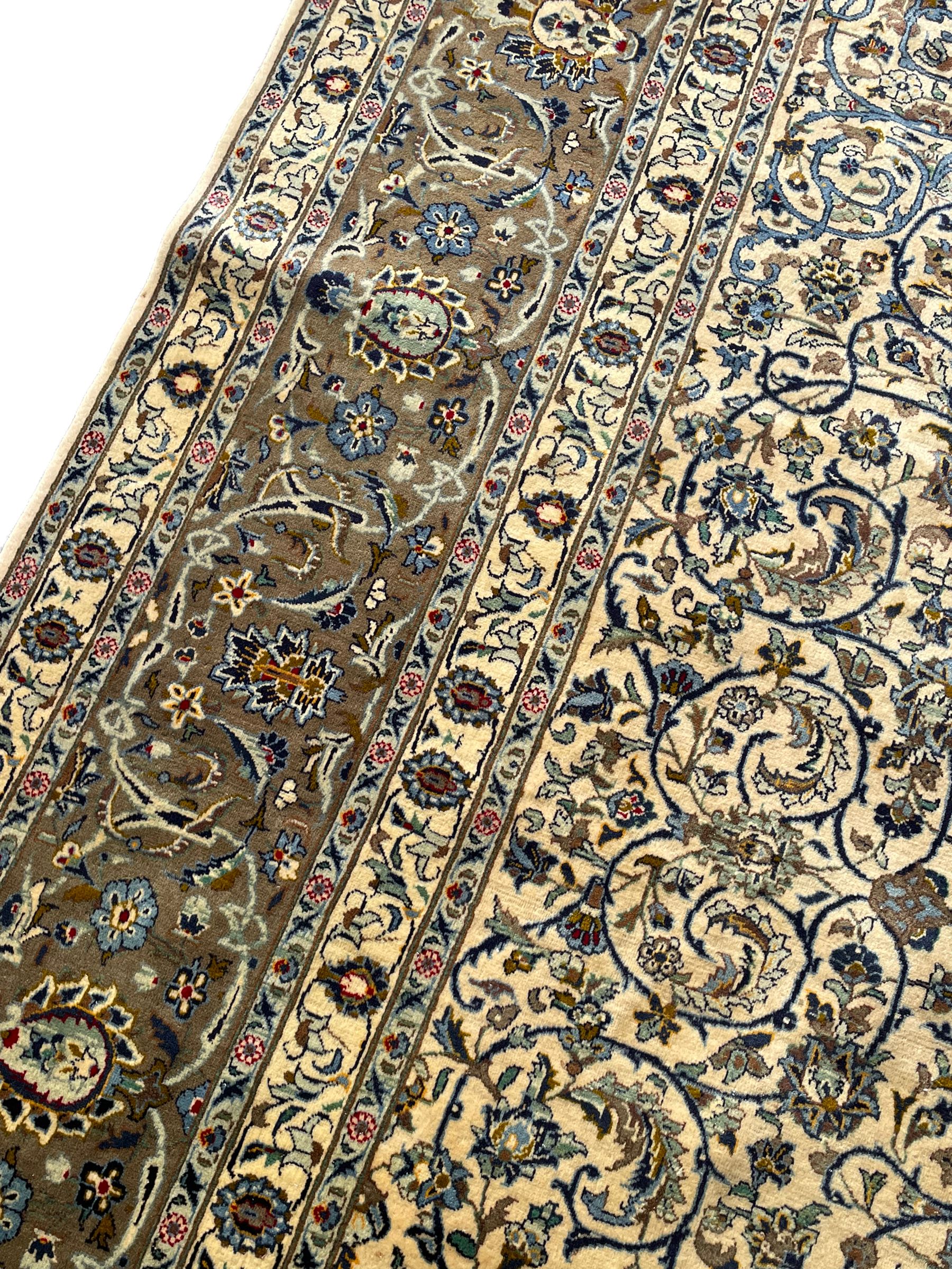 Persian Meshed carpet, ivory ground and decorated with intricate floral design with trailing scrolled branch, the central medallion decorated with stylised plant motifs, seven band border, the main band decorated with scrolls and flower head motifs