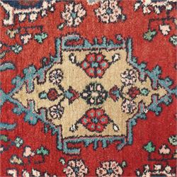 Small Persian crimson ground Hamadan rug, decorated with central medallion surrounded by stylised foliate motifs with repeating guard lines