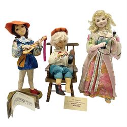 Anna Meszaros Hungary - three hand made needlework figurines - 'The Cobbler' as a child seated in a wooden rocking chair working on a removed boot H28cm; young girl in a long floral dress standing playing a harp H35cm; and young girl wearing a blue tabard standing playing a lute (3) Auctioneer's Note: Anna Meszaros came to England from her native Hungary in 1959 to marry an English businessman she met while demonstrating her art at the 1958 Brussels Exhibition. Shortly before she left for England she was awarded the title of Folk Artist Master by the Hungarian Government. Anna was a gifted painter of mainly portraits and sculptress before starting to make her figurines which are completely hand made and unique, each with a character and expression of its own. The hands, feet and face are sculptured by layering the material and pulling the features into place with needle and thread. She died in Hull in 1998.  