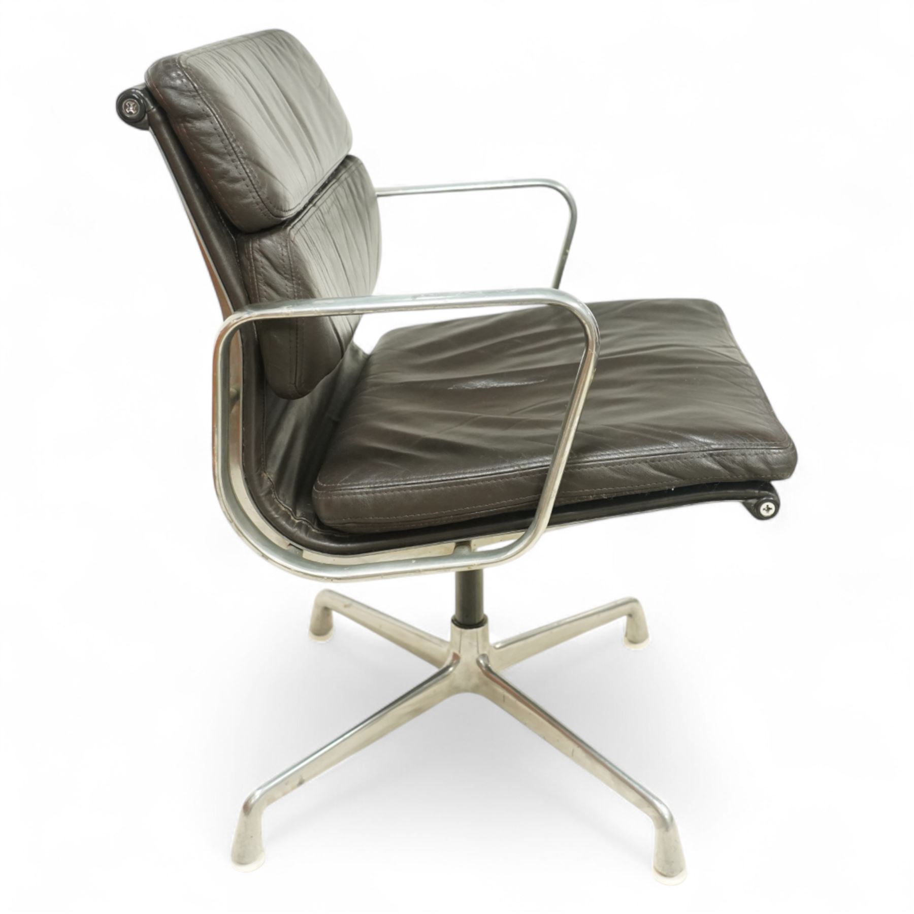 Charles and Ray Eames for Herman Miller - 1970s soft pad office chair model 'EA 207', low back and seat upholstered in chocolate brown leather flanked by open aluminium arms, raised on a non-swivelling aluminium base with manual screw adjustment function