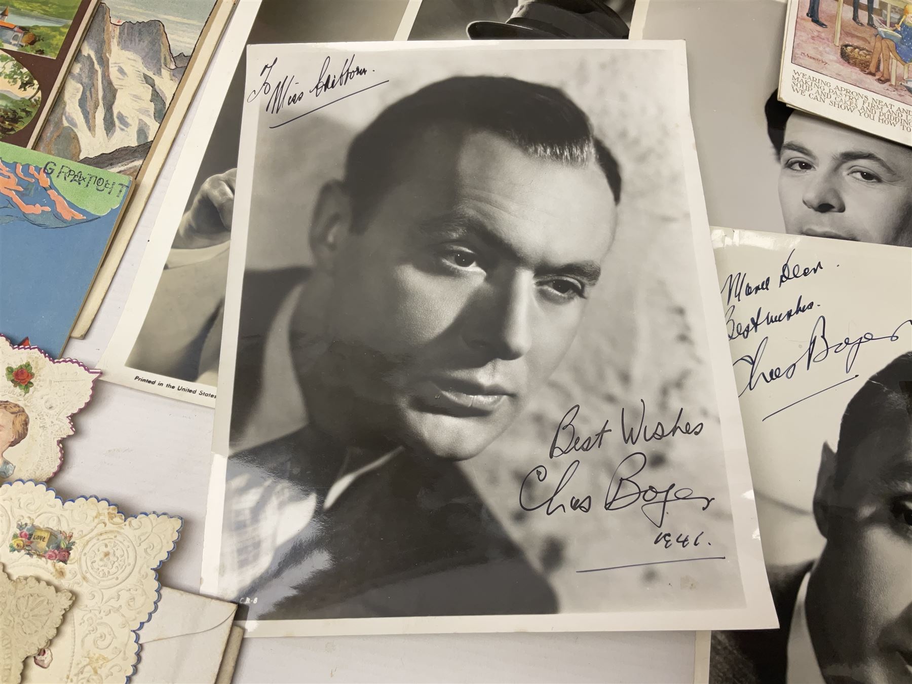 Early 20th century ephemera, to include signed photographs of Charles Boyer and Walter Pidgeon etc, a printed letter from Winston Churchill, two albums and a quantity of transfer books of Players and similar cigarette cards, including Boy Scout and Girl Guide Patrol Signs and Emblems and RAF Badges, a collection of greetings cards and postcards, a photograph album containing black and white photographs of Caius College Cambridge and guides and pamphlets on travelling Switzerland and the UK