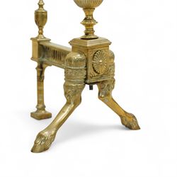 19th century brass and iron fire dogs with fire irons, the fire dogs each with urn finials and arched legs, accompanied by three brass fire tools including shovel, poker and tongs with matching turned handles