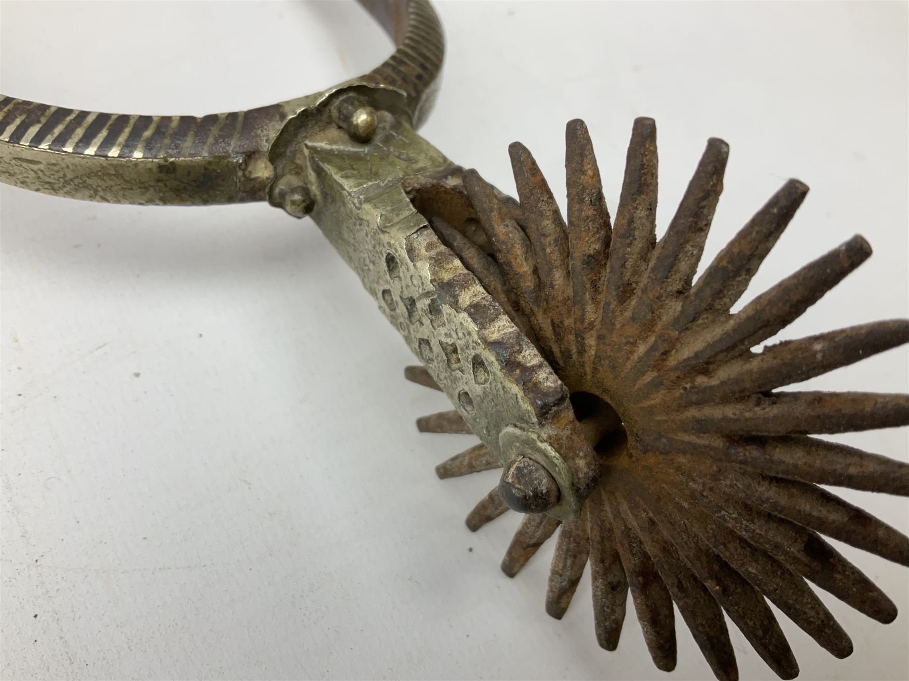 Pair of late 19th century South American iron spurs, engraved silver mounts, with sunburst rowls