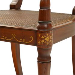 Pair of Sheraton Revival painted mahogany open armchairs, scrolled cresting rail with floral painted decoration over a double-caned back and rose-branch painted back bar, cane seat over C-scroll-painted seat rail, on splayed tapering supports, with all-over painted ebony faux stringing