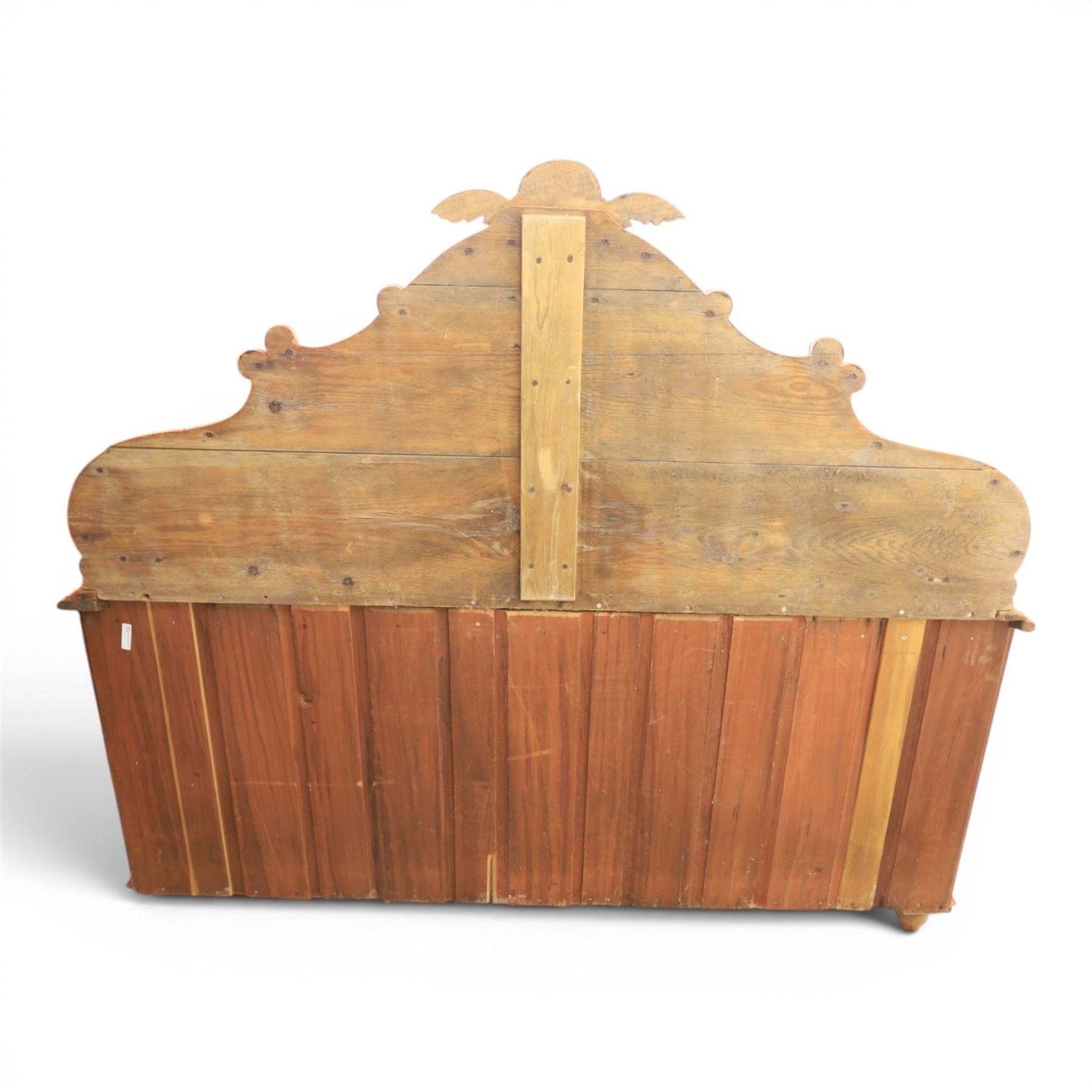 Victorian pine chiffonier, shaped moulded top with raised scroll carved back surmounted by carved fruit and foliate crest, fitted with two frieze drawers over two panelled cupboard doors, the outer cupboards of bowed form, carved foliate corbels, on plinth base