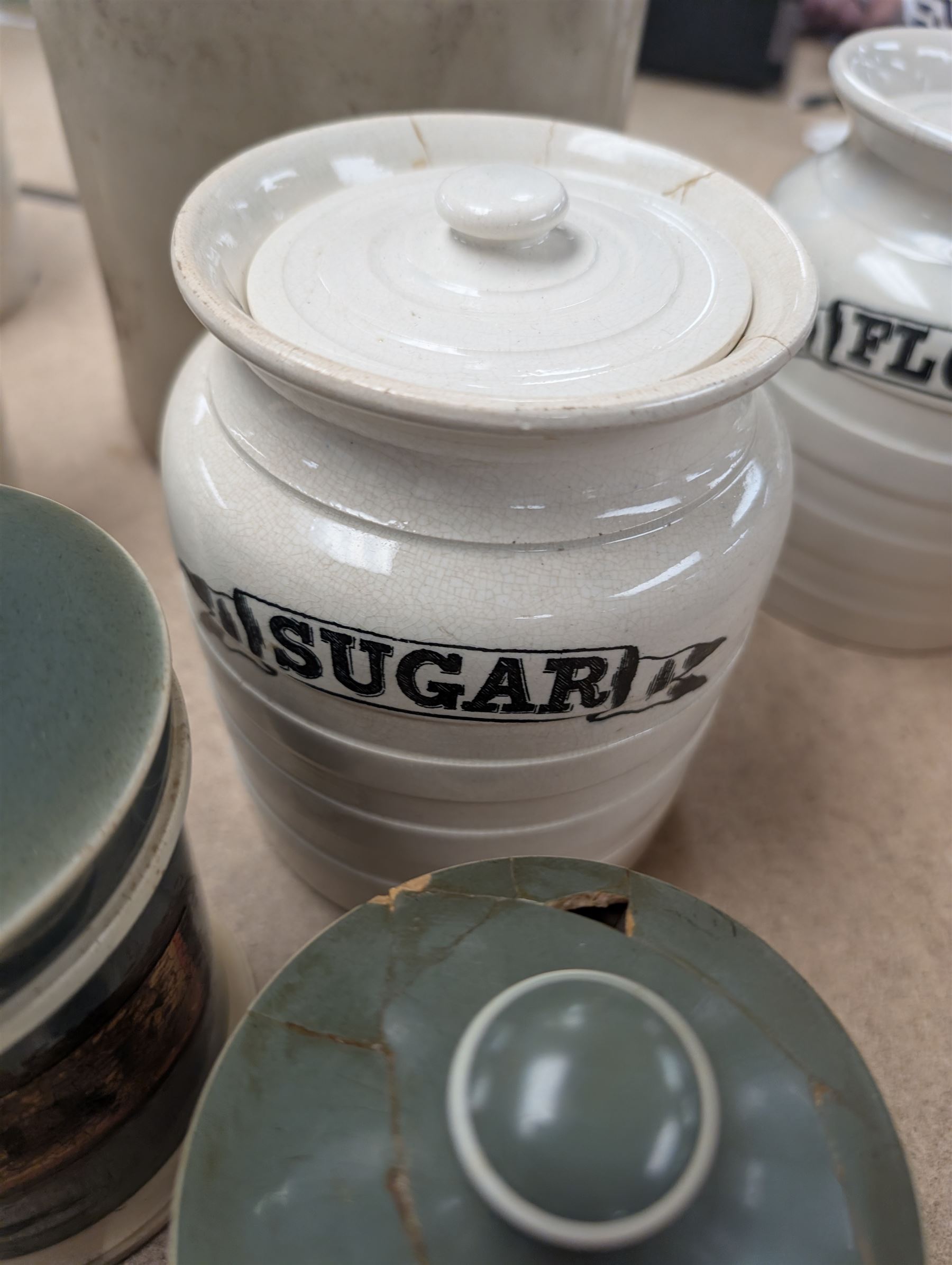19th century sage green apothecary jars with gilt labels, four white ceramic kitchen jars and a stoneware flaggon marked Wheat Wine