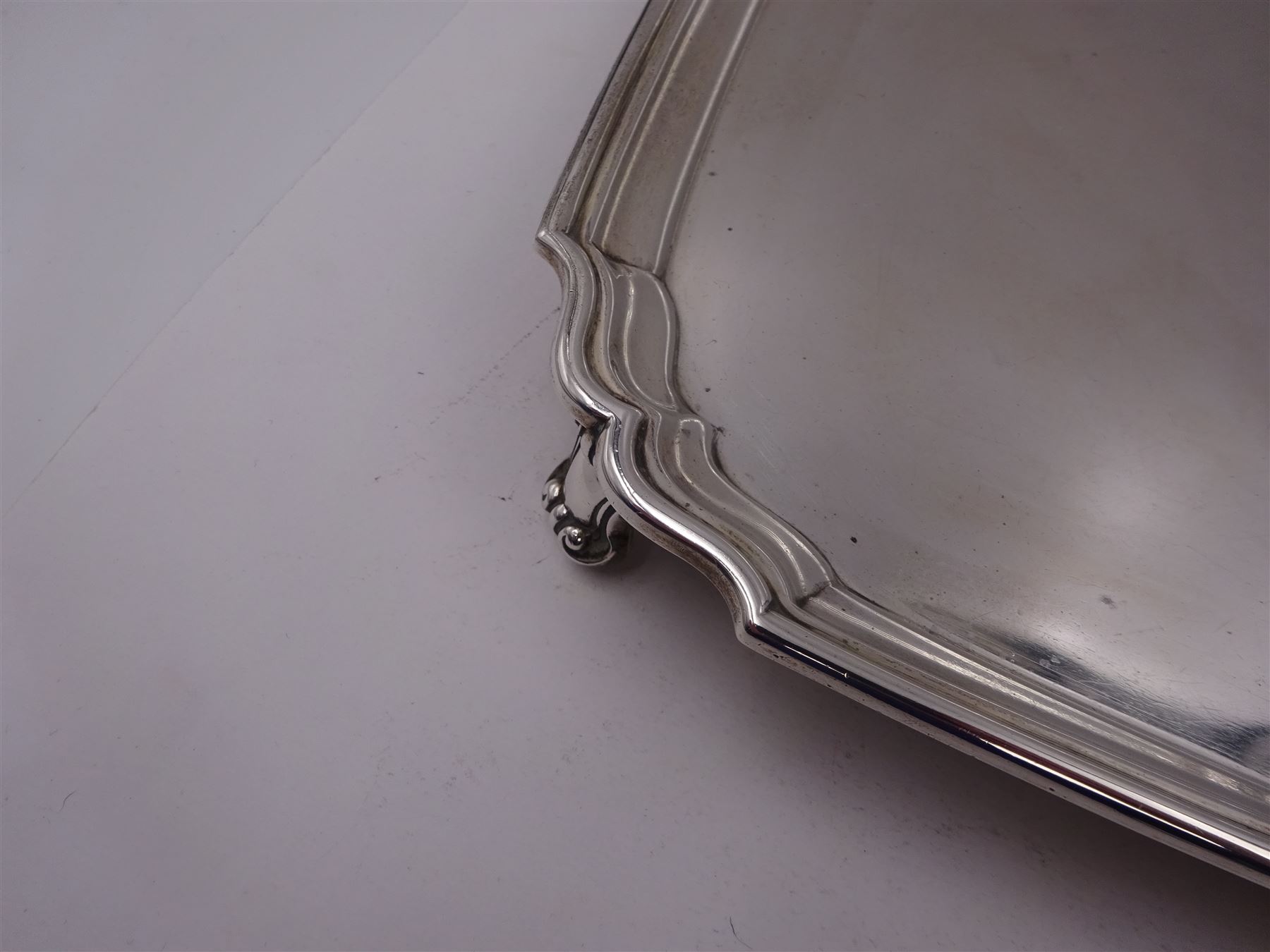 1930s silver tray, of square form with shaped canted corners and stepped rim, upon four bracket feet, hallmarked Frank Cobb & Co Ltd, Sheffield 1936, W31cm