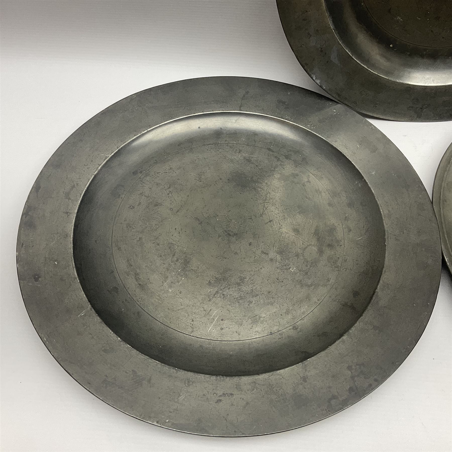 Group of seven 19th century pewter chargers, each of circular form with dished centre, two examples with touch marks verso, each approximately D39cm