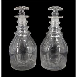 Pair of early 19th century decanters of mallet form, with part sliced and cut decoration, triple faceted ring necks and mushroom stoppers, H24cm