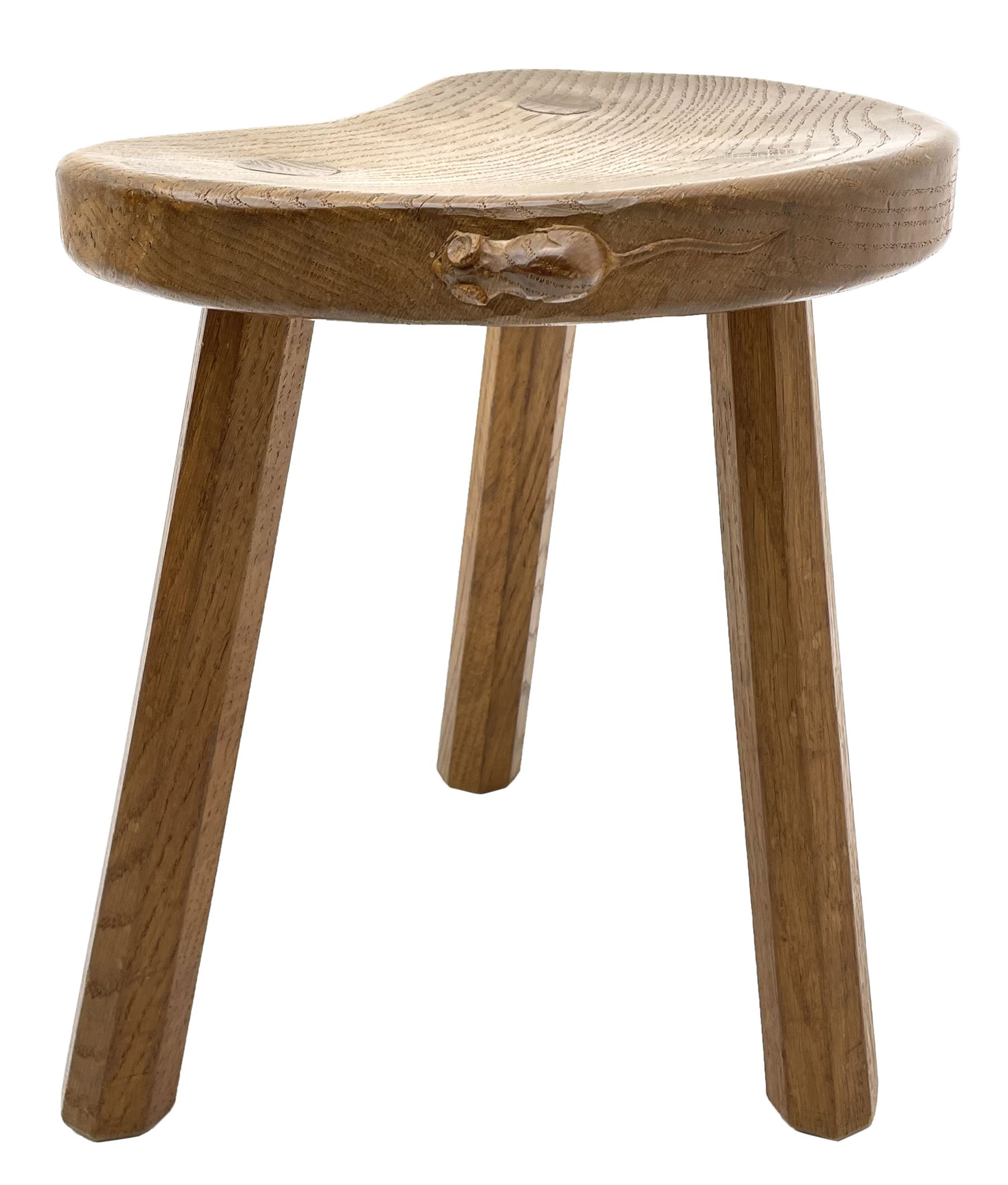 'Mouseman' oak three legged stool with dished kidney shaped seat, tapered octagonal supports, with carved mouse signature, by Robert Thompson of Kilburn 