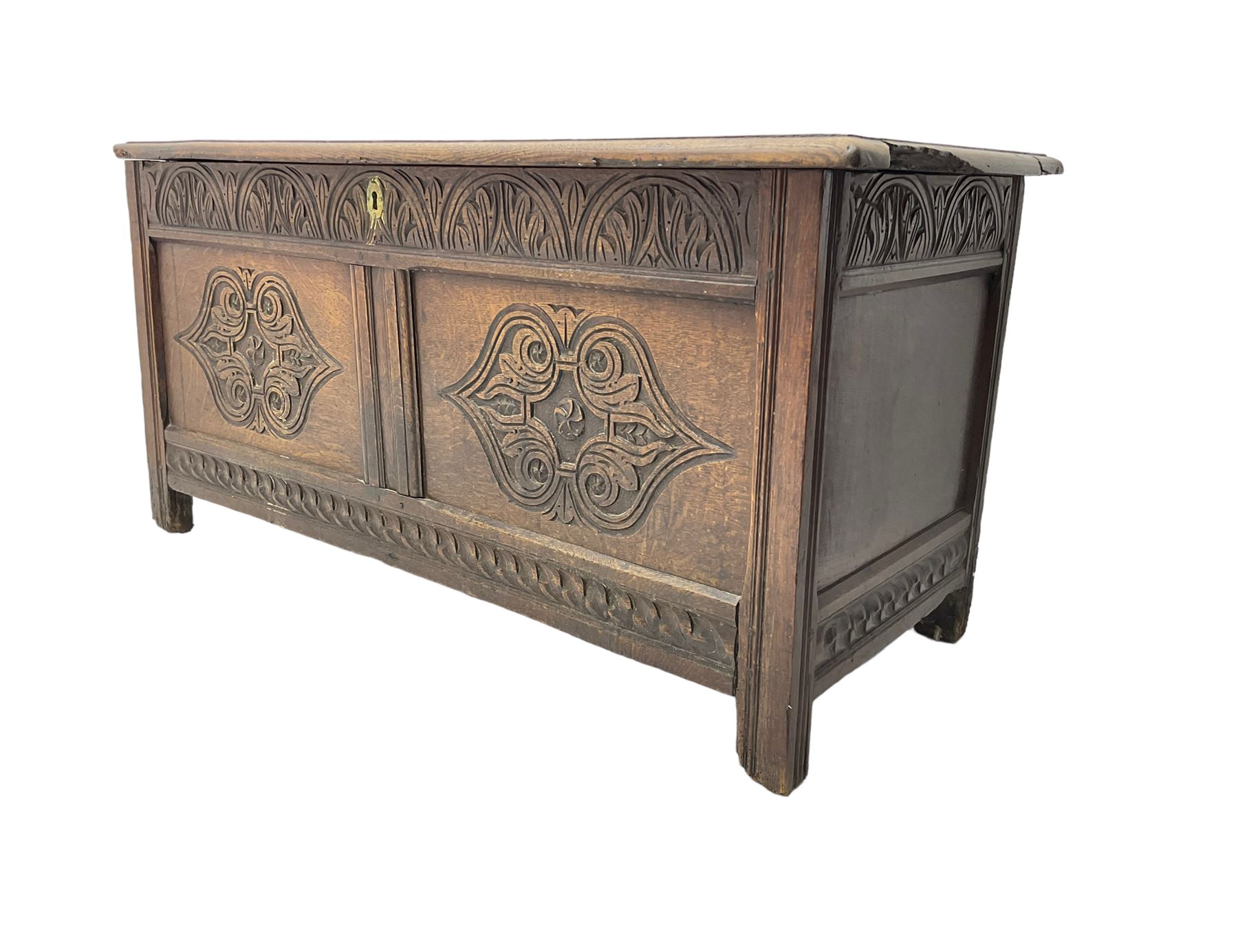18th century oak blanket chest or coffer, rectangular hinged top with three panels and moulded edge, frieze carved with lunette and acanthus leaf decoration, two front panels carved with scrolling motif, raised on stile supports