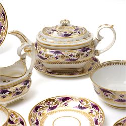 Early 19th century Derby tea and coffee service painted with a border pattern of purple and gilt leaves and flowers comprising four large cups with five saucers, nine coffee cans with twelve saucers, tea pot and stand, slop bowl, milk jug and two plates, red painted mark.