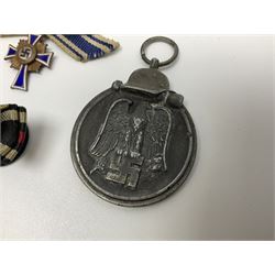 Four German awards - pre-WW2 two-position button hole ribbon for 1914 Iron Cross; WW1 wound badge open back cut-out version with silvered finish; miniature version Mother's Cross with ribbon bow; and The Eastern Medal, officially the Winter Battle in the East 1941–42 Medal (4)