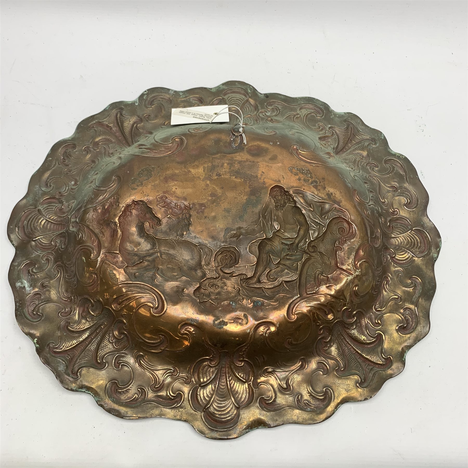 Large Newlyn School oval copper wall plaque, the dished centre embossed with a study of Neptune riding the waves, within a scrolling border with wavy rim, W48cm, H42cm