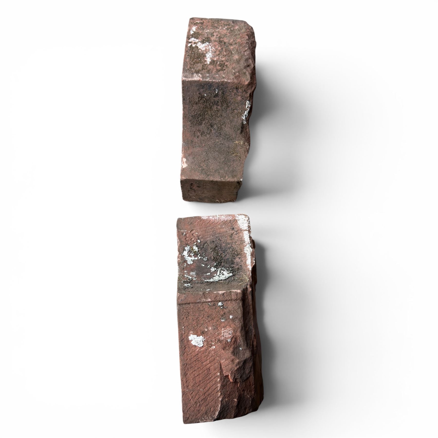 Pair of 19th century hewn and carved stone wall ends, the facias carved as shaped faux fielded panels