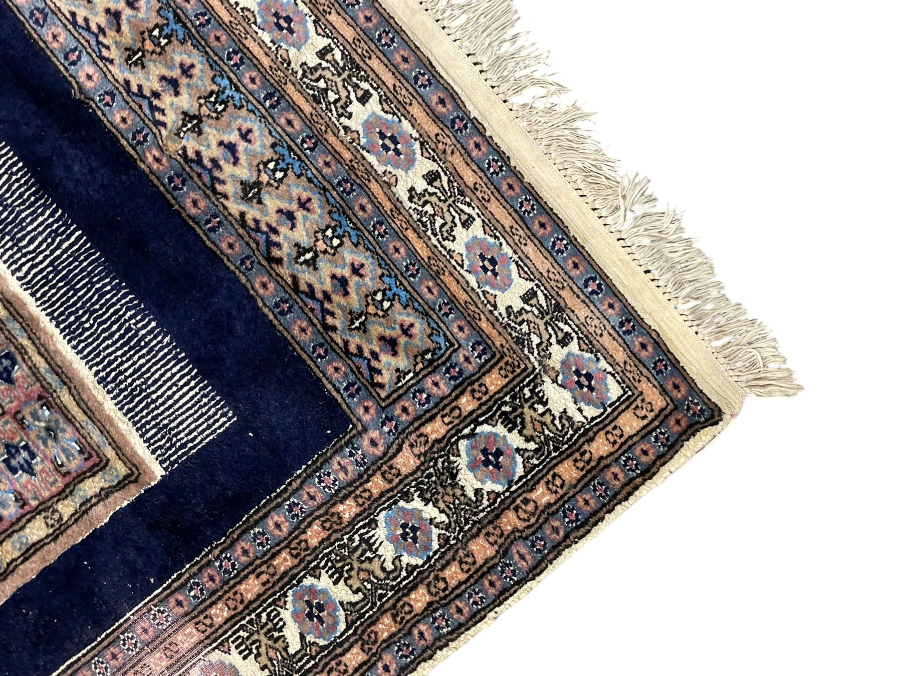 Indo-Persian indigo ground rug, the field depicting a rug with floral medallion and spandrels, enclosed within multiple floral pattern border bands
