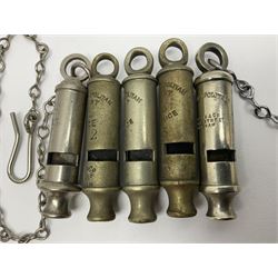 Three Hull City Police 'Metropolitan' whistles by J. Hudson 13 Barr Street Birminham, each with impressed collar number; another 'Metropolitan' police whistle with chain; and an ARP whistle by Hudson & Co with chain (5)