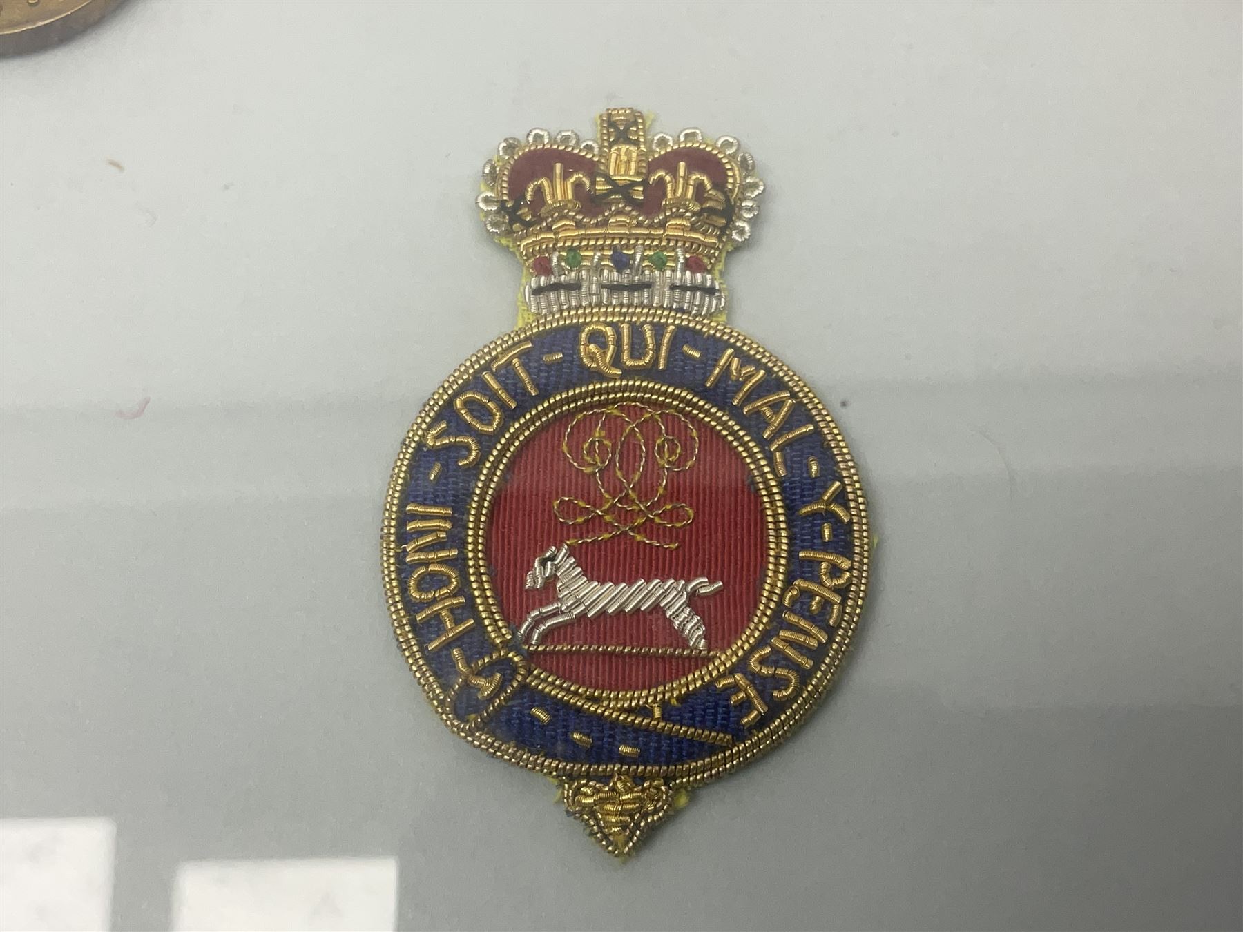 Victorian / Edward VII Queens Own Hussars Officers Full Dress Pouch and Cross Belt; scarlet cloth covered leather pouch with bullion embroidered crown, laurel bordered regimental crest within an edge of embroidered bullion wire; with its original officers cross belt with fine regimental pattern brocade to the top and gilt metal furniture; displayed in a wall hanging case with cloth and metal regimental badges; mahogany stained frame 44 x 54cm