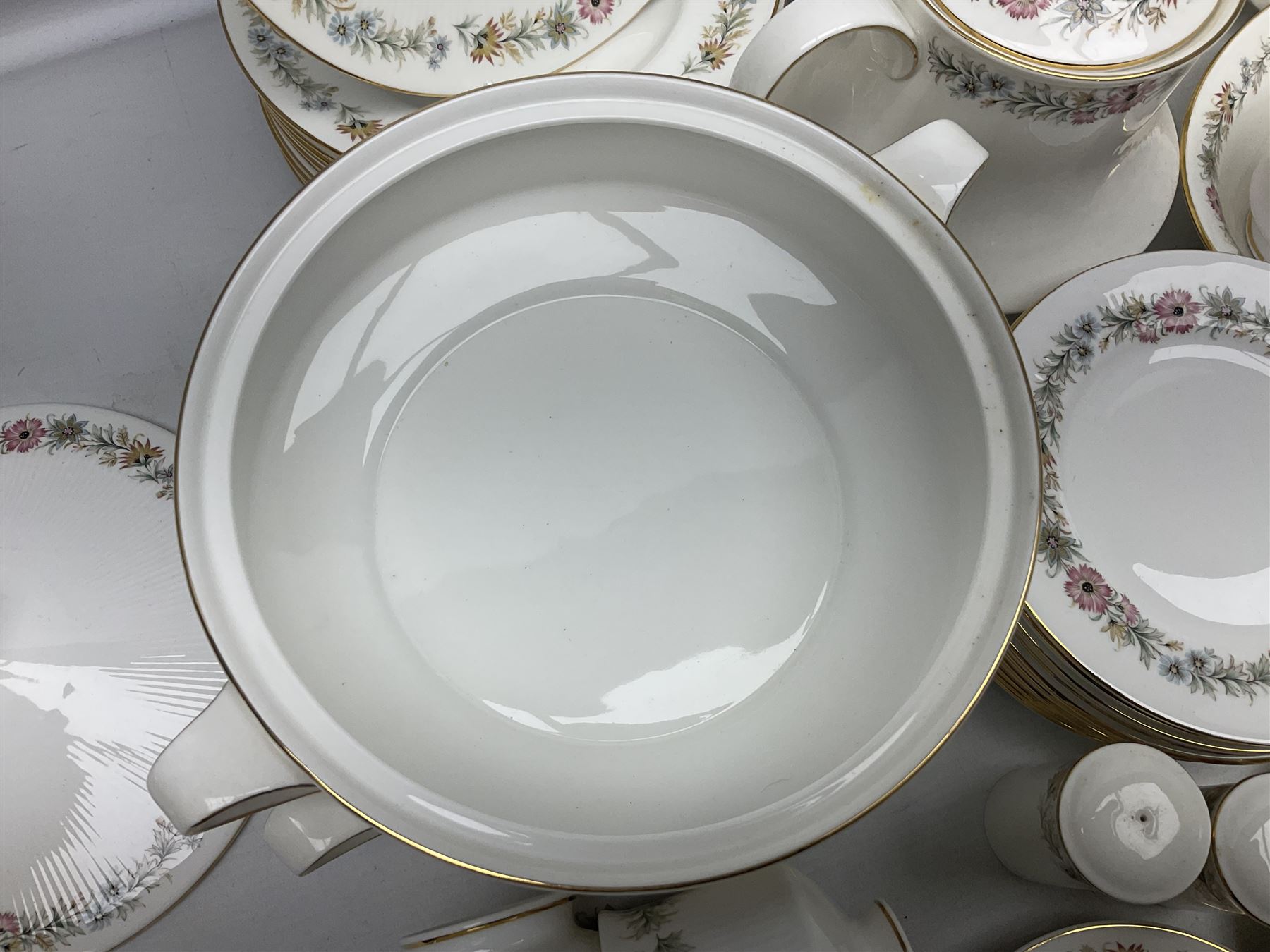 Royal Albert Paragon tea and dinner service for twelve decorated in the Belinda pattern, comprising fourteen saucers, twelve teacups, thirteen side plates, teapot, sauce boat and stand, salt and pepper shakers, two jugs, sucrier, twelve dinner plates, twelve smaller plates, two lidded tureens, twelve bowls, twelve smaller bowls, cake plate, oval plate and oval dish (100)