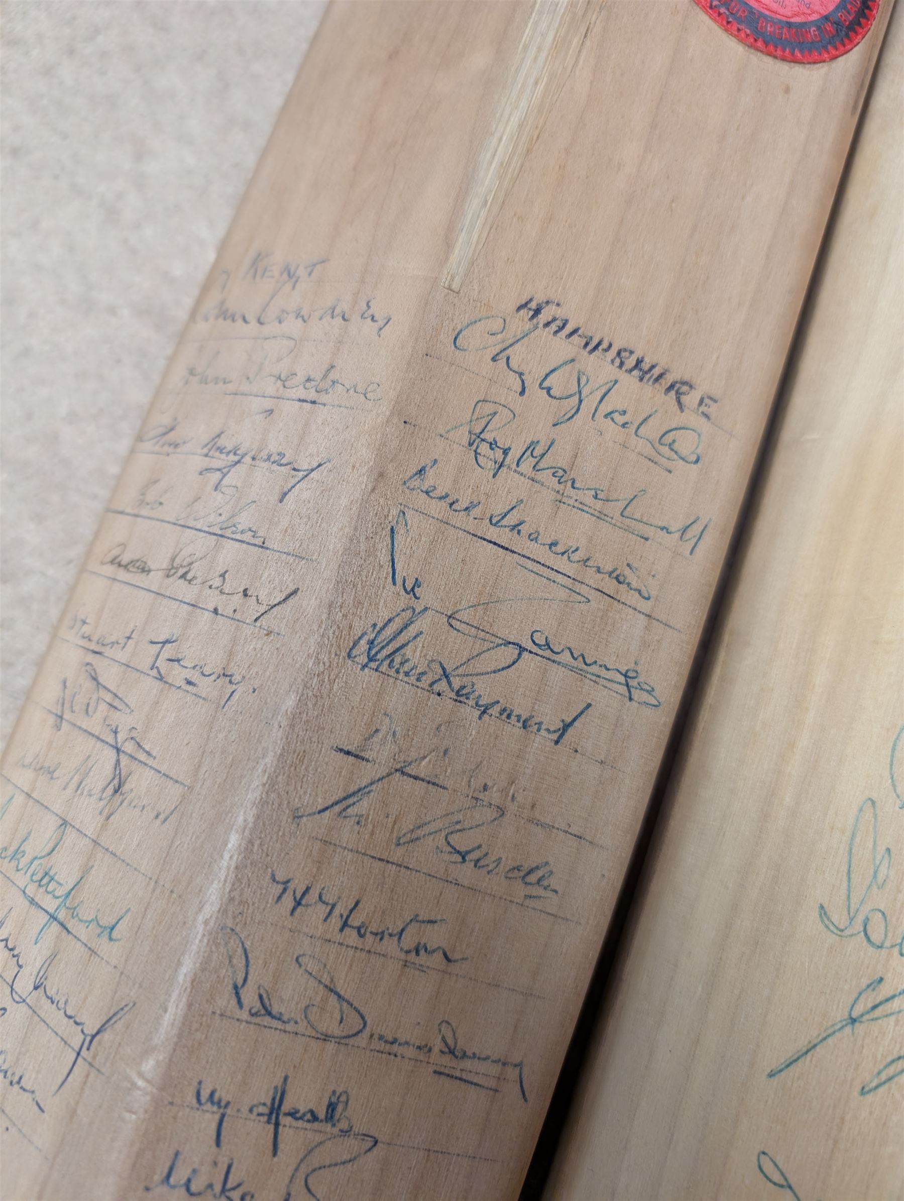 Two signed cricket bats, with signatures including Colin Cowdrey