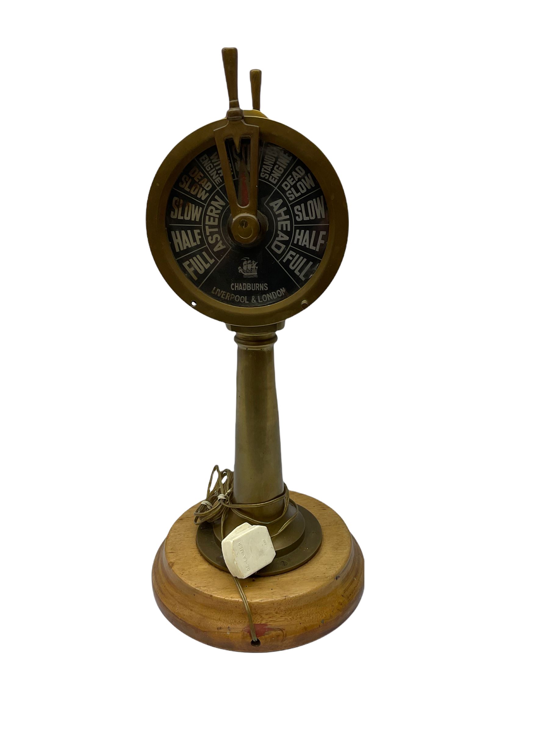 Early 20th century, illuminating brass ship's telegraph by Chadburns of Liverpool and London, on a circular wooden plinth, H55cm