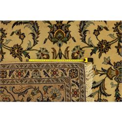 Central Persian Kashan carpet, ivory ground, field with an all-over design of scrolling palmettes and floral sprays in blue and terracotta within a beige ground and pale blue floral border