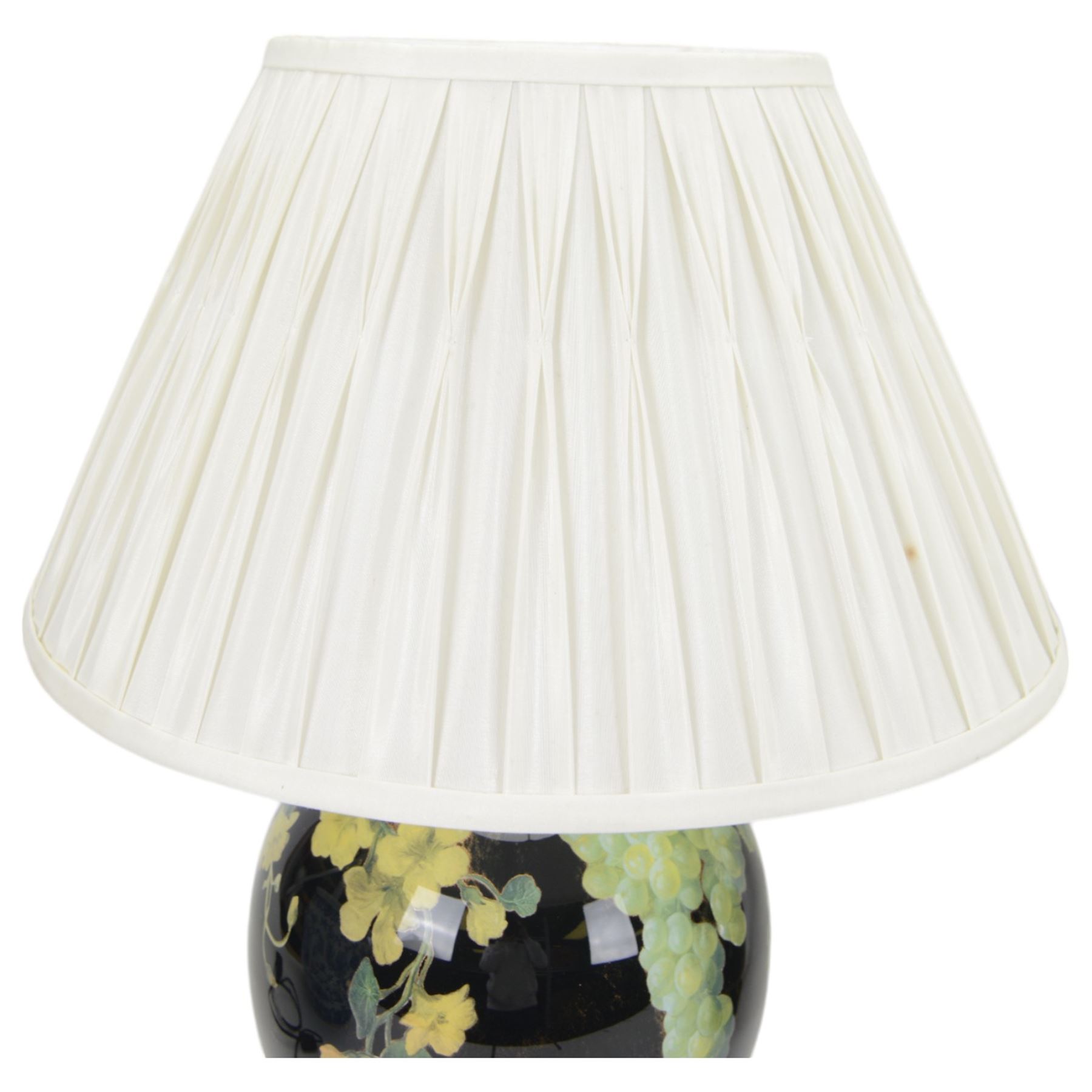 Pair of Jenny Worrall table lamps, of ovoid form, the glass body decorated with fruit and trailing flowers upon a black ground with gilt flecks, with pleated cream lampshades, including shades H65cm