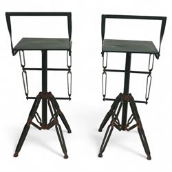 Pair of 20th century brutalist industrial metal swivel bar stools, sheet seats with strap backrests with bolted design to the sides, raised on quadripod bases with angular strut supports, the seats height-adjustable and swivelling