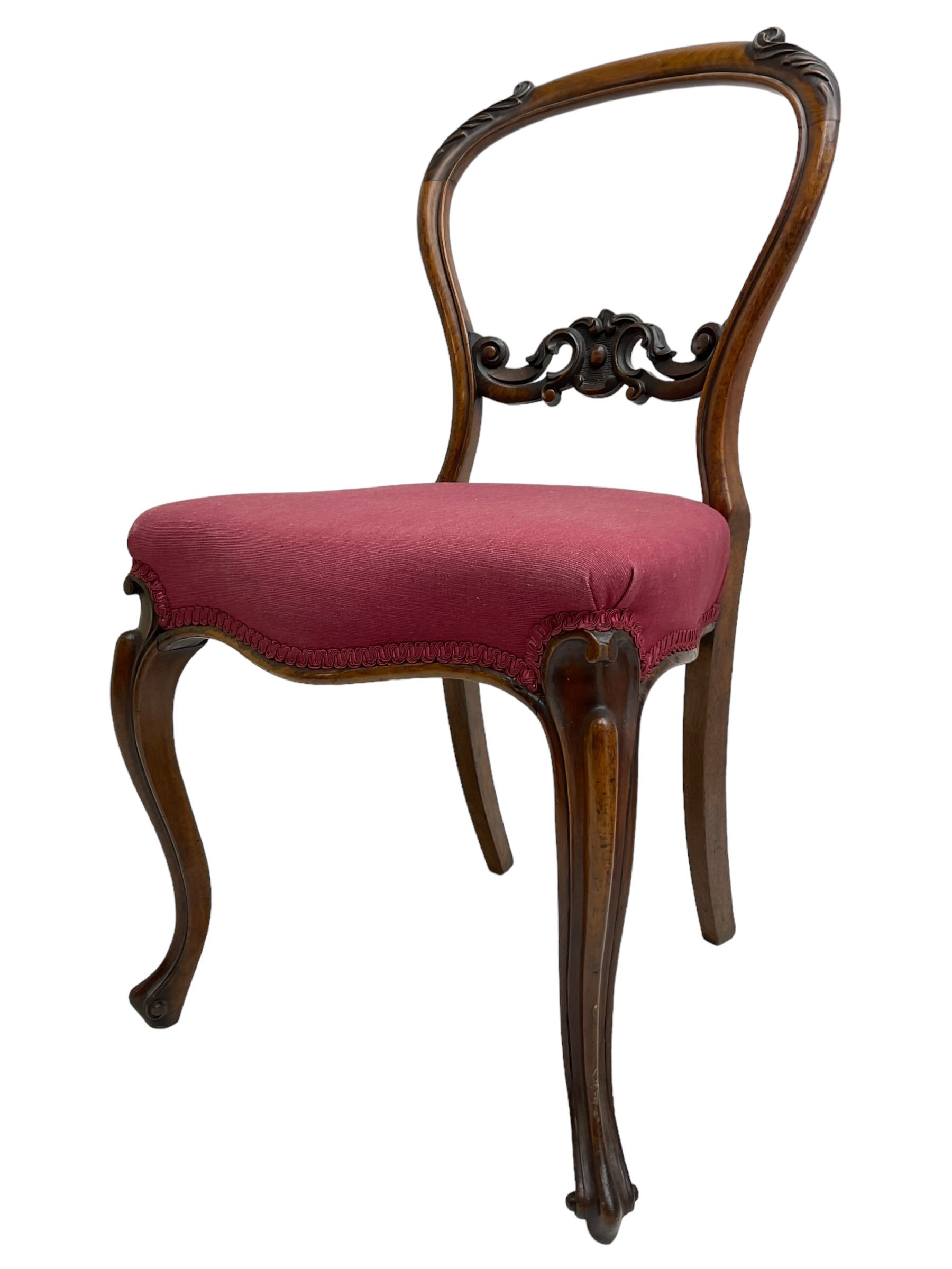 Set of six Victorian rosewood dining chairs, the balloon back carved with foliage scrolls, cartouche carved middle rail with extending scrolls, the seats upholstered in pink fabric, on carved cabriole supports with scrolled terminals 
