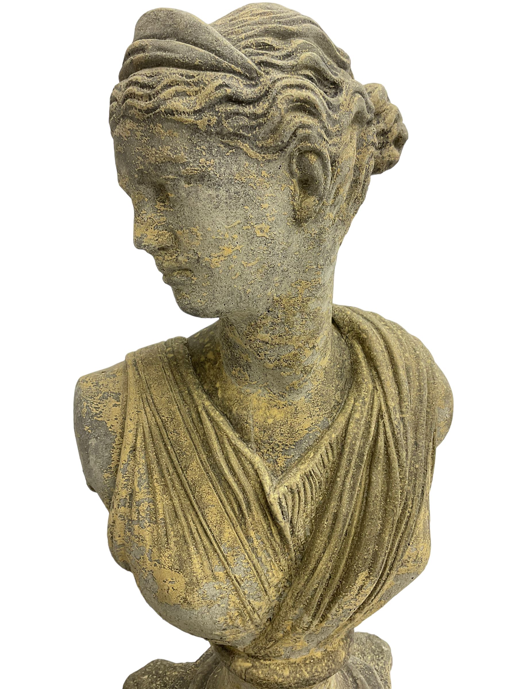 Classical design cast stone female bust depicting Artemis, raised on fluted Corinthian column with acanthus leaf capital, stepped square base, looking right 