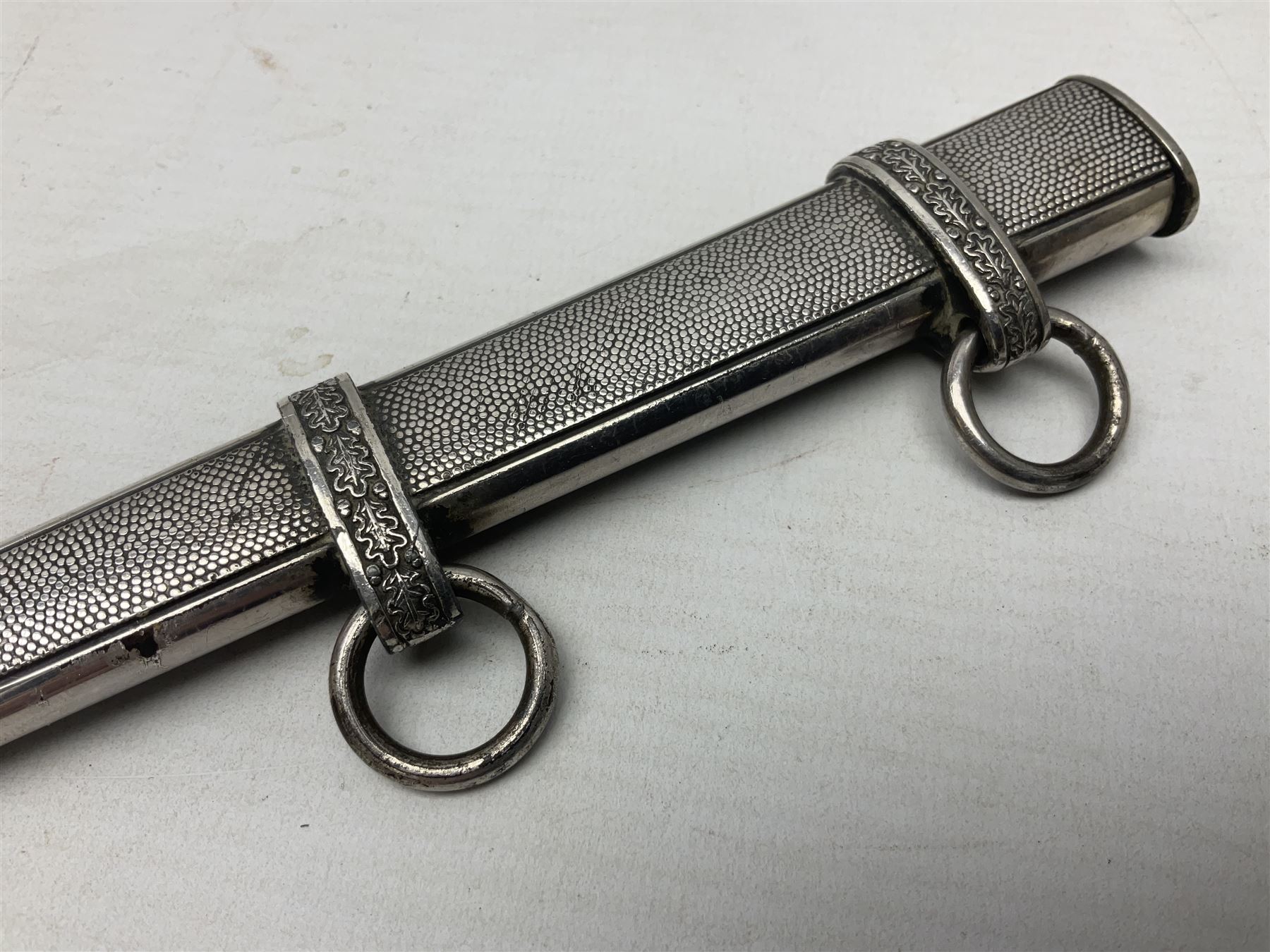 Late WW2 German Army Officers dress dagger, with unmarked 25cm double edged steel blade, orange celluloid grip, pommel and ferrule with oakleaves relief and cross guard with eagle; in original beaded scabbard with two hanging rings L39.5cm overall