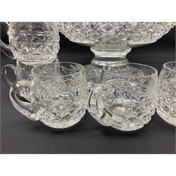 Large Stuart crystal pedestal punch bowl, of circular form, the rim with engraved floral decoration, upon spreading circular foot with radial cut decoration, with seven matching Stuart crystal drinking glasses, each with a C handle, each acid signed beneath, bowl H20cm