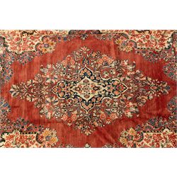 West-Central Persian Mahal hand-knotted carpet, terracotta field with a large central indigo and ivory medallion with floral palmettes and scrolling vines, framed by ivory spandrels with dense foliage within a broad navy border of lotus and palmette motifs linked by scrolling tendrils and multiple guard stripes 