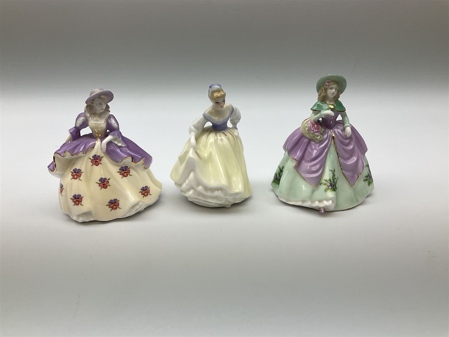 A group of figures, comprising four Royal Worcester examples, The Milkmaid, Lady Emma, Lady Cicely, Lady Hannah, three Royal Doulton examples, Top o' the Hill HN1849, Margaret HN2397, Fair Lady HN3216, two Coalport examples Fairest Flowers Heather, and Pansy, and a Wedgwood figure commissioned by Spink, The Imperial Banquet. 