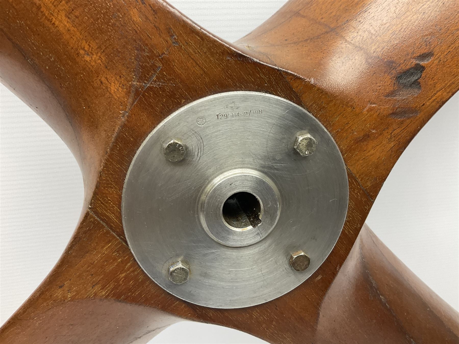 British World War II era laminated wooden four-bladed generator propeller, late 1930s-40s, used to power a drogue winch used by a target tug aircraft; marked with DRG drawing number T29505-2-4 N760 on the hub and impressed circle mark 'P.M.P.W. 1'; light weight four plank mahogany laminate with 9.5cm diameter metal plates mounted to front and rear faces of hub for 15mm shaft; one plate marked T29504-2/198 D91cm; together with a modern reproduction brass edged mahogany two-blade propellor L