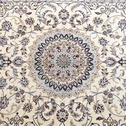 Central Persian Nain hand-knotted carpet, wool with silk highlights, ivory field with central radiating medallion surround by an intricate arrangement of scrolling vines and floral motifs, within conforming spandrels and matching border, cotton fringe ends 