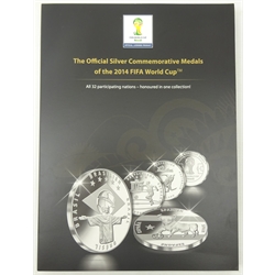  'The Official Silver Commemorative Medals of the 2014 FIFA World Cup', all thirty two silver medals in capsules, in official folder which has not been written in  