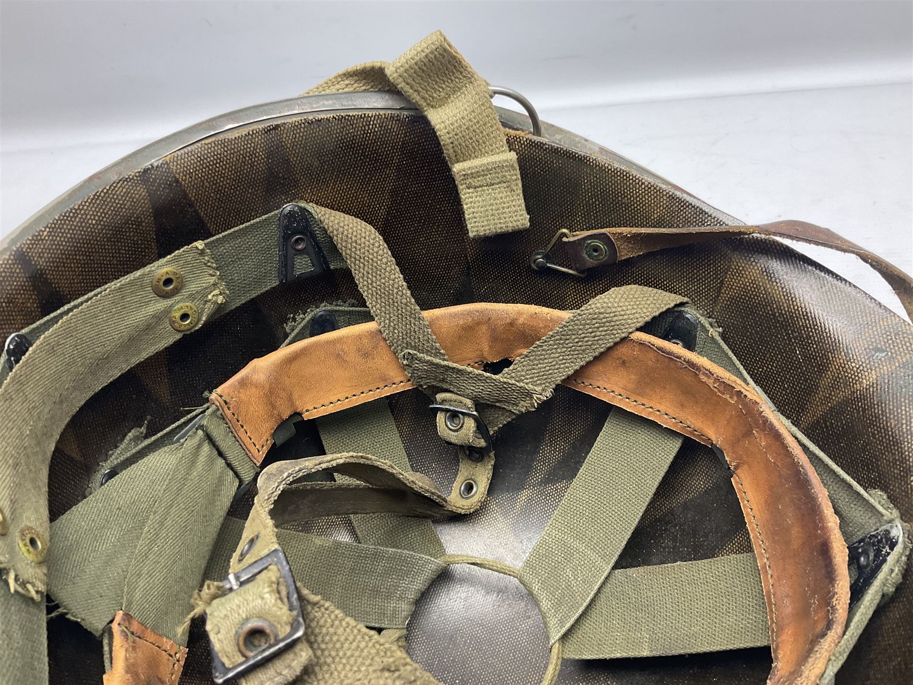 American first type paratrooper helmet with post-WW2 strap and D-rings and later 1944 liner bearing Firestone Tyre and Rubber Company mark; green textured finish