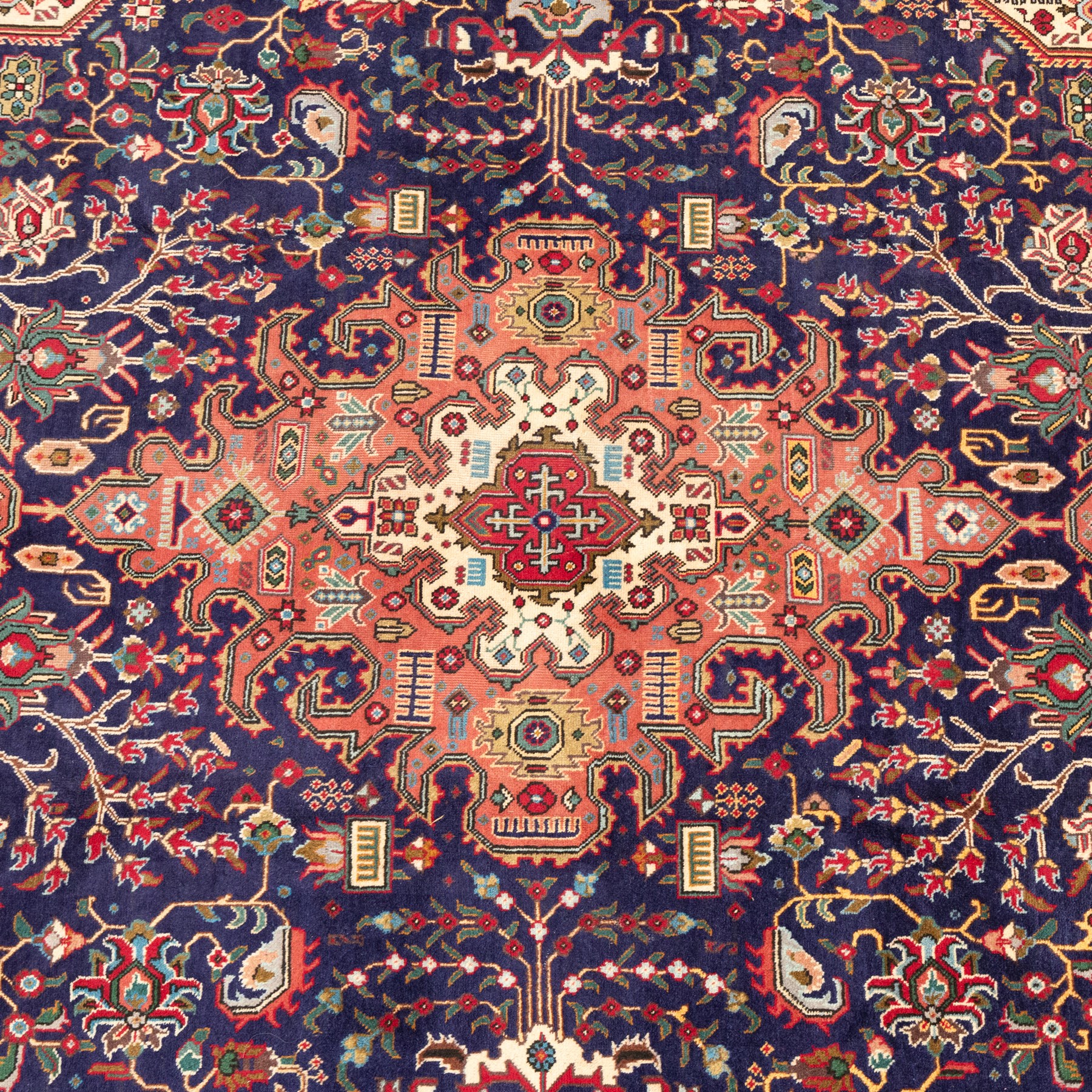 North West Persian carpet, the indigo field centred by a large terracotta and ivory medallion with matching pendants, decorated throughout with stylised palmettes, flowerheads and branching foliage, ivory geometric floral spandrels, enclosed by a red palmette border and narrow patterned guard bands
