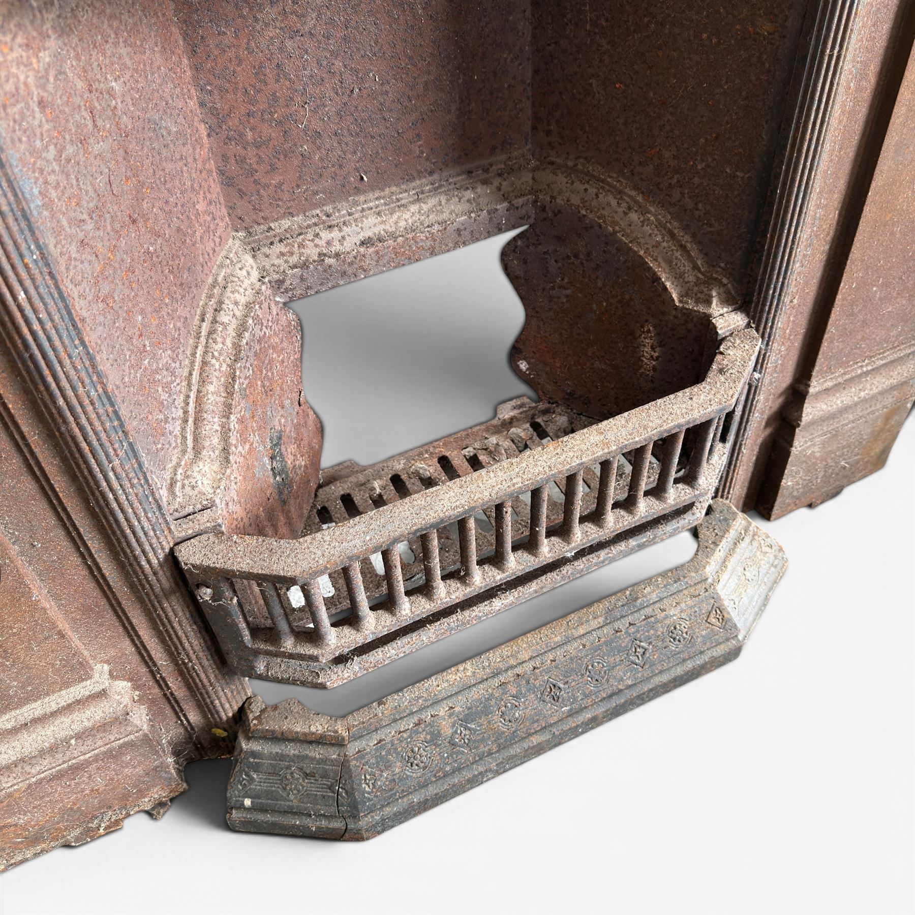 Late Victorian cast ion bedroom fireplace, decorated with floral poppy motifs and flluting