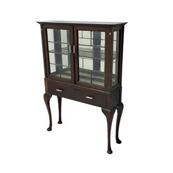 Early 20th century mahogany display cabinet, enclosed by two lead glazed doors, inlaid with Art Nouveau design stylised tulip in mother of pearl and boxwood, fitted with two drawers, on cabriole supports 