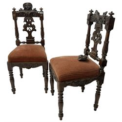 Pair of 19th century heavily carved oak side chairs, cresting rail with carved Putti mask over pierced and carved splat with ornithological decoration, sprung seat upholstered in red fabric over foliate and scroll carved frieze, on turned supports