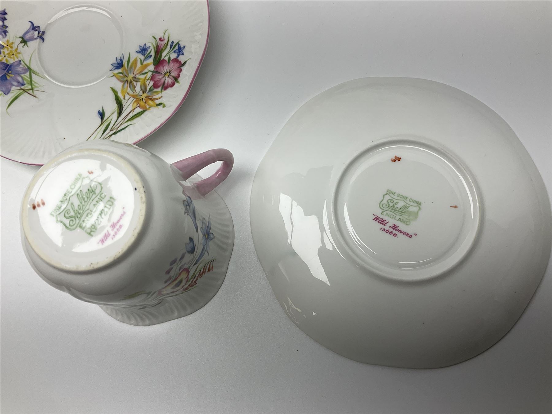 Shelley Wild Flowers pattern part tea service, comprising four cups and saucers, four dessert plates, cake plate, milk jug and open sucrier
