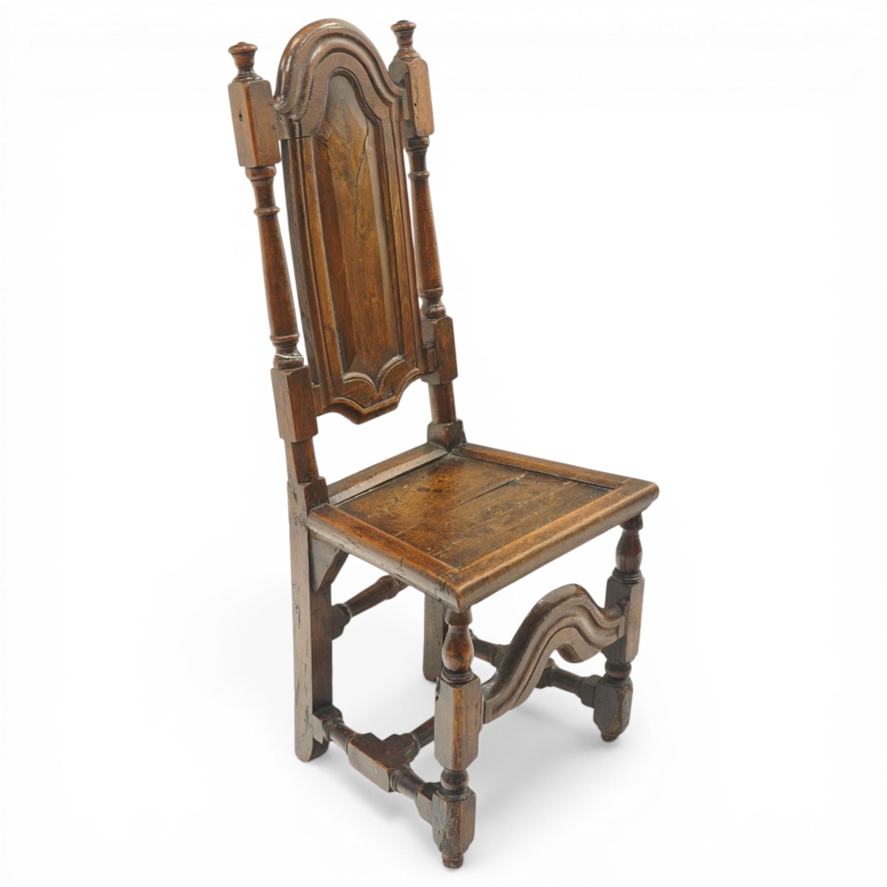 17th century oak and elm hall chair, the high-back with shield-shaped fielded panelling flanked by turned uprights, over a panelled seat, raised on turned supports united by H-stretcher with moulded serpentine front-stretcher