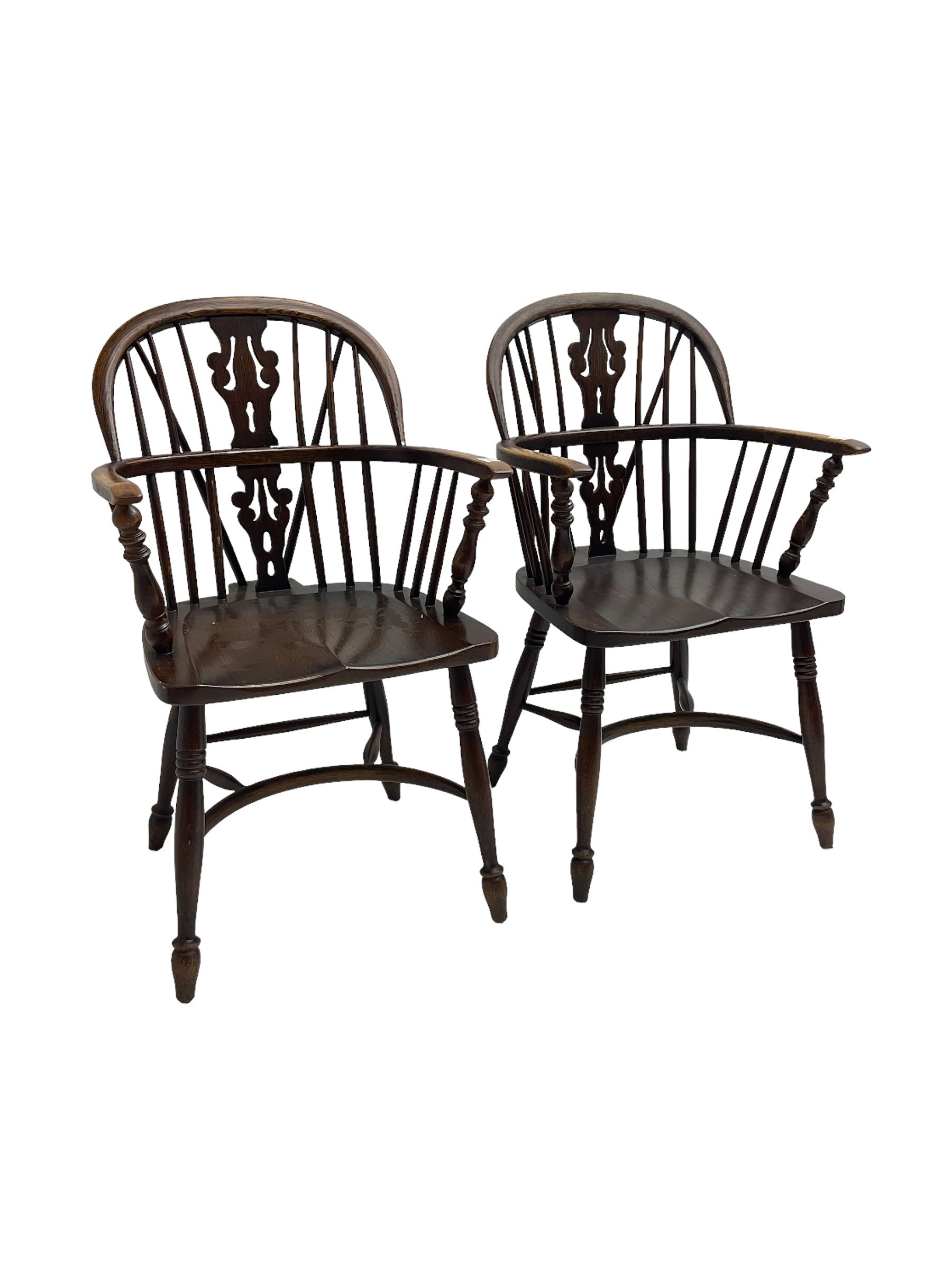 Pair late 20th century oak Windsor elbow chairs, double hoop and stick back with pierced and fretwork work splat, dished seat on turned supports joined by crinoline stretcher