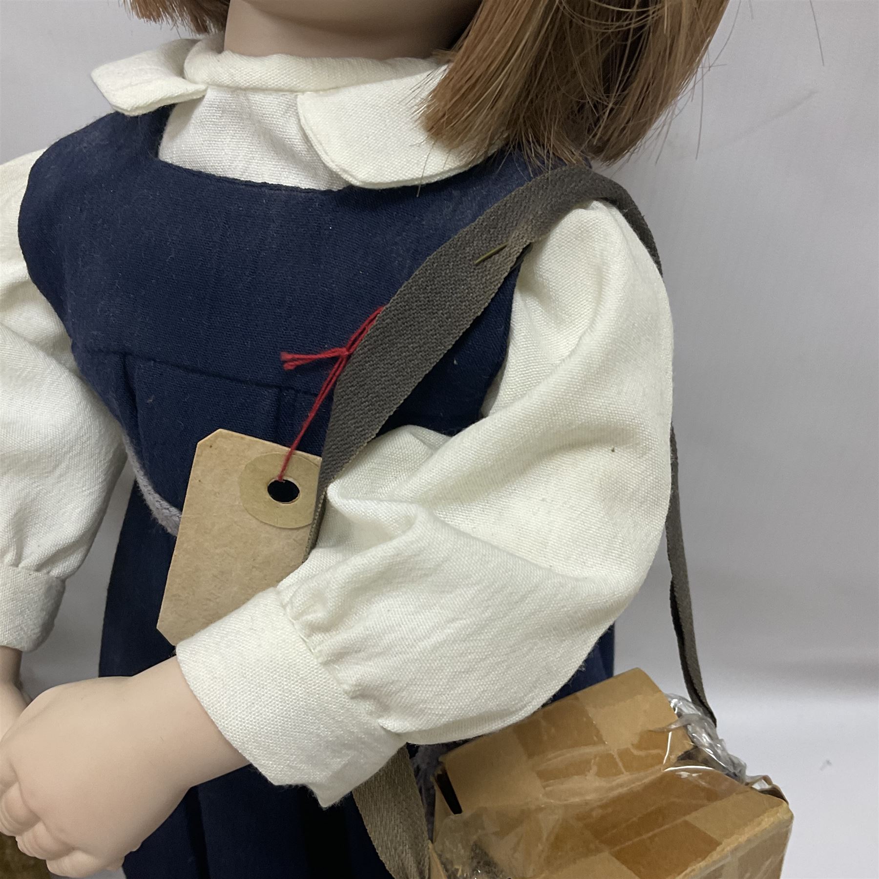 Mid-20th century woodwool filled teddy bear; and porcelain doll dressed as a WW2 evacuee