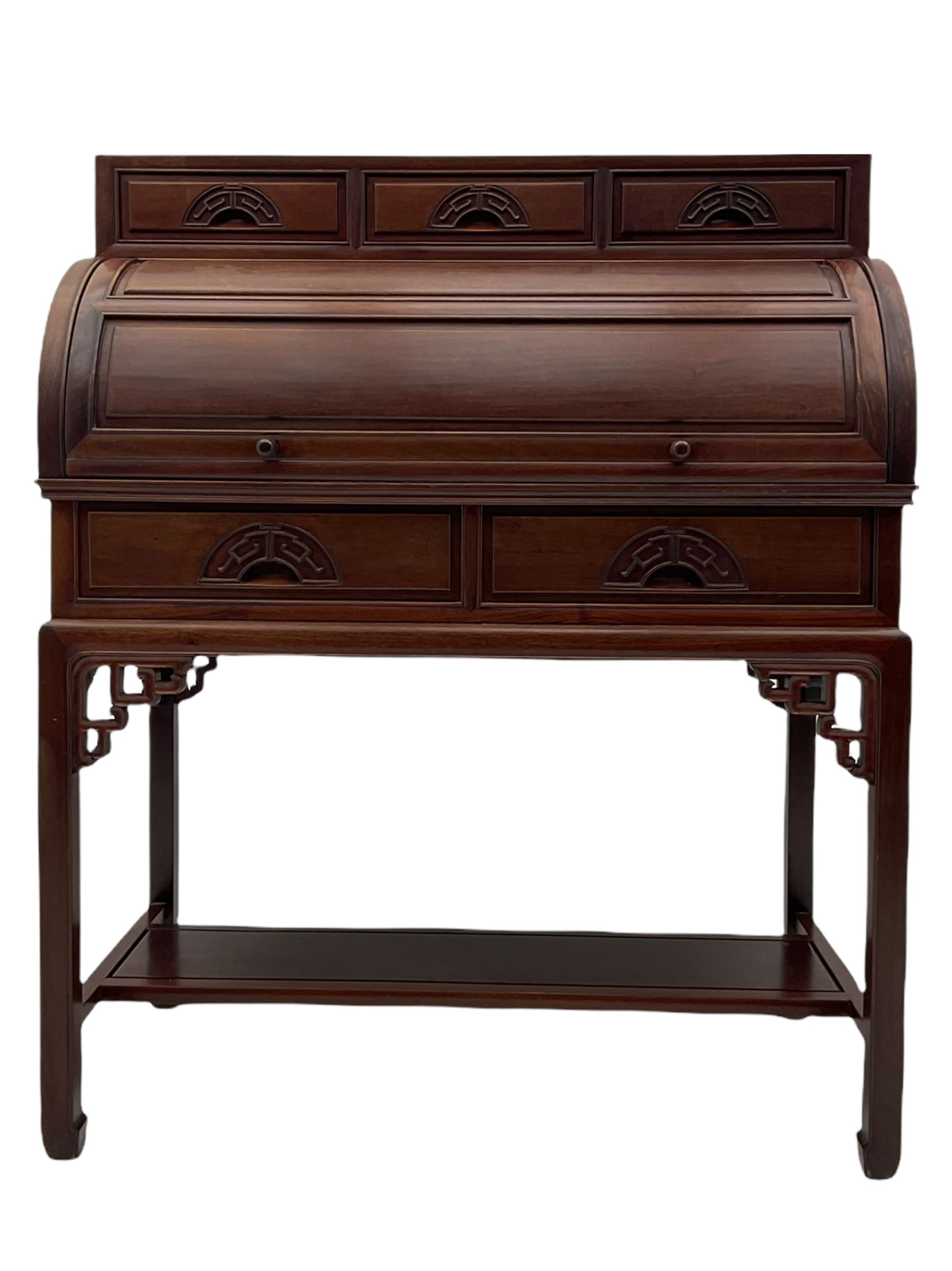 Hardwood cylinder desk, three drawers raised over curved lid, fitted interior with slide, the supports joined by undertier with fret work brackets 
